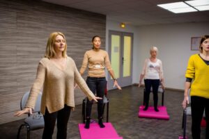 Femmes en posture de relaxation pratiquant la sophrologie.